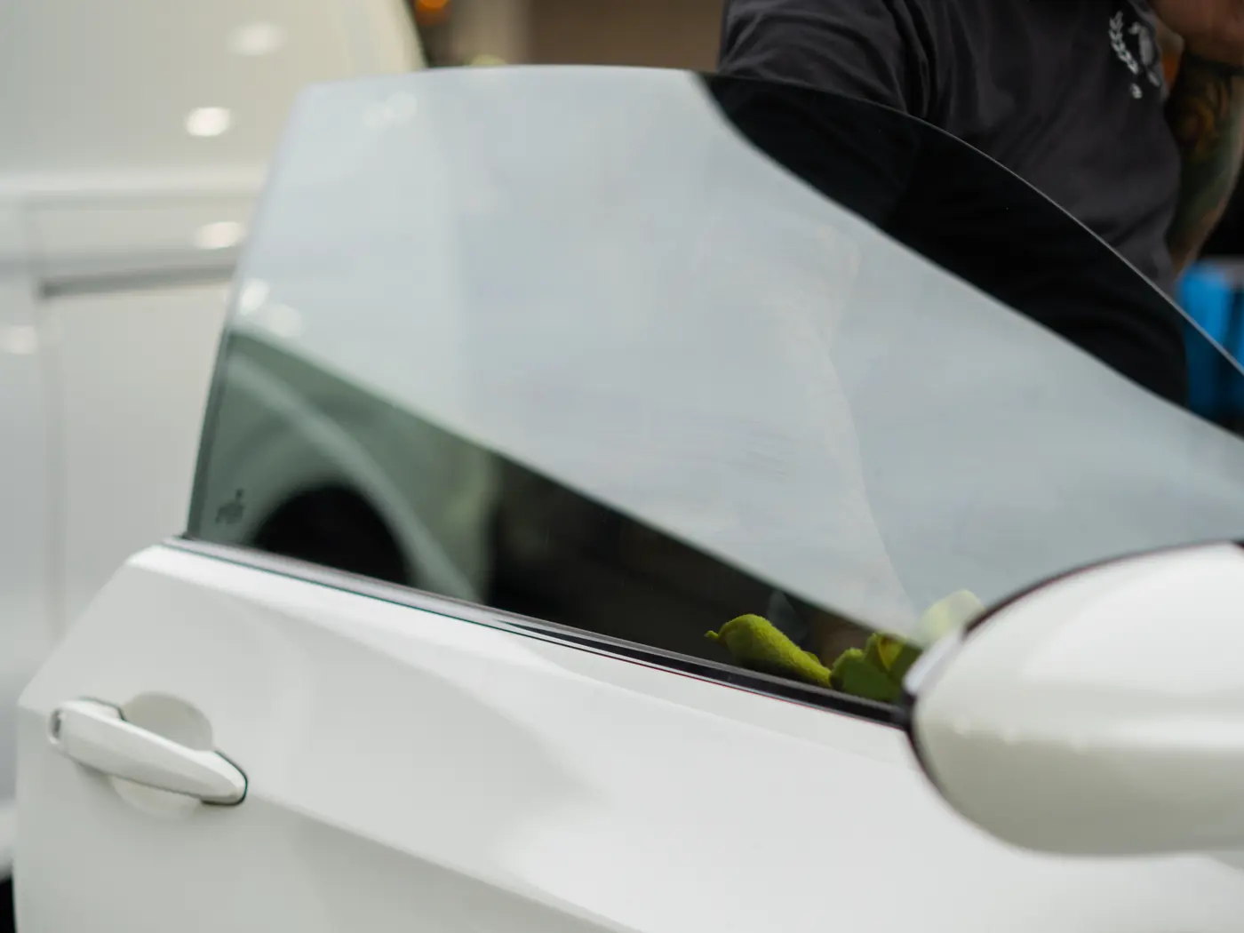 Tinted rear door glass on a white sedan